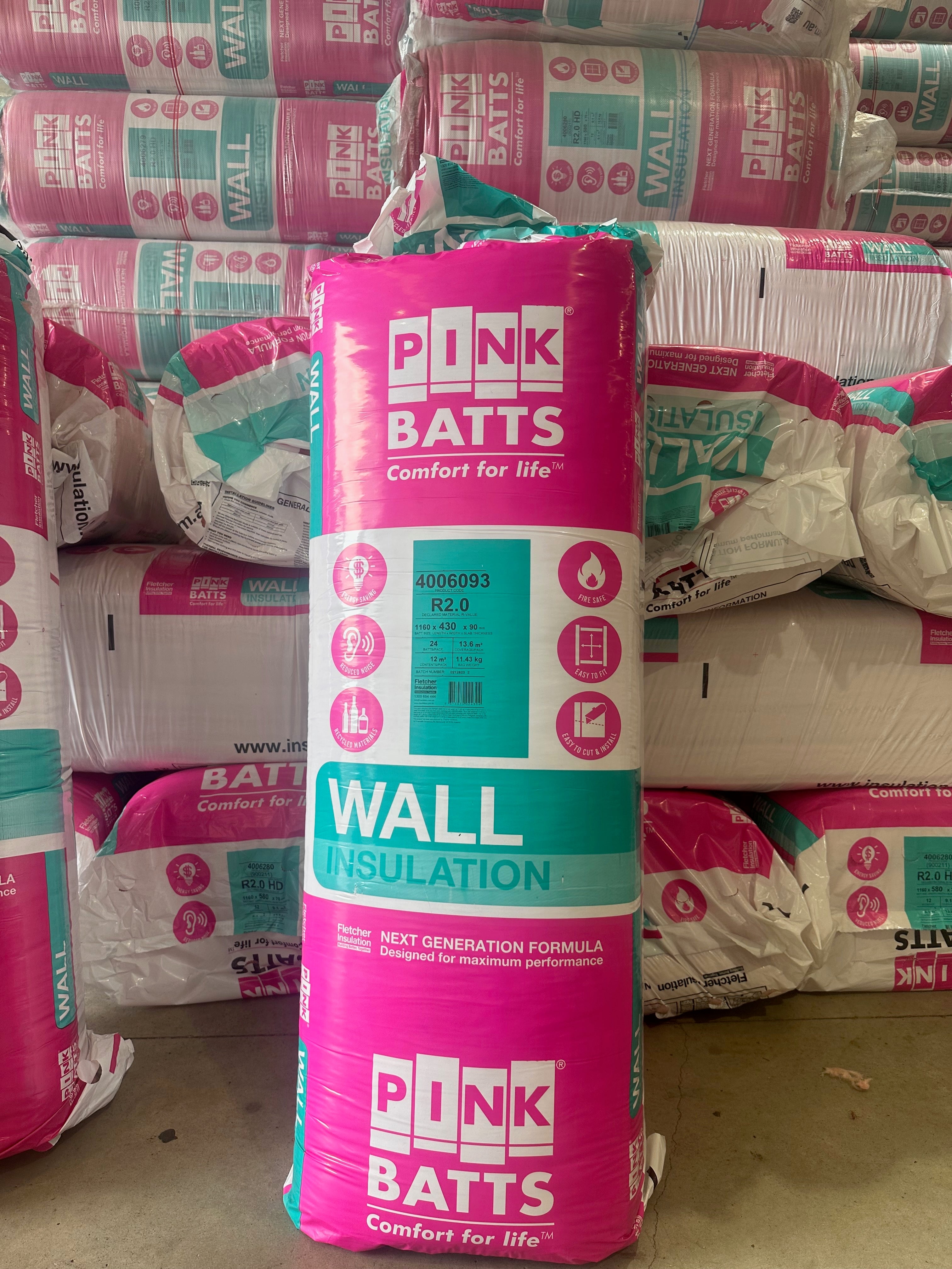 Pink Batts wall insulation packaging with a stack of similar packages in the background. Melbourne Insulation Online